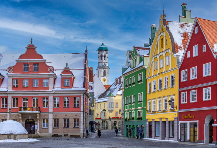 Brightly painted houses and pitched roofs in town square of Memmingen, Bavaria with blue sky