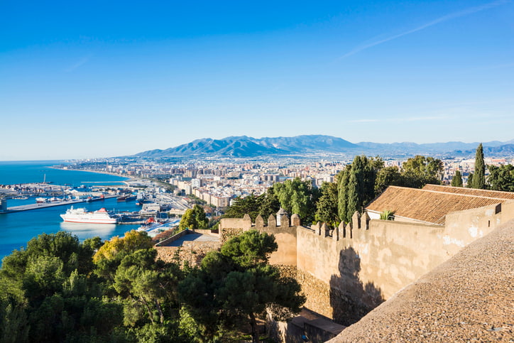 Malaga port and castle Spain, historic buildings, blue sky and blue sea