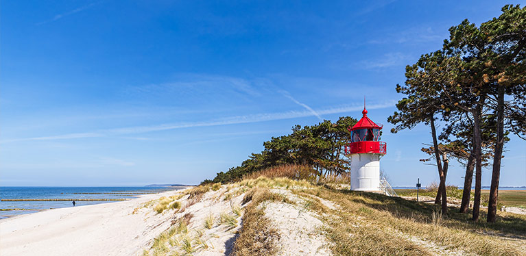 Insel-hiddensee beach in Germany showing white sand and red topped lighthouse
