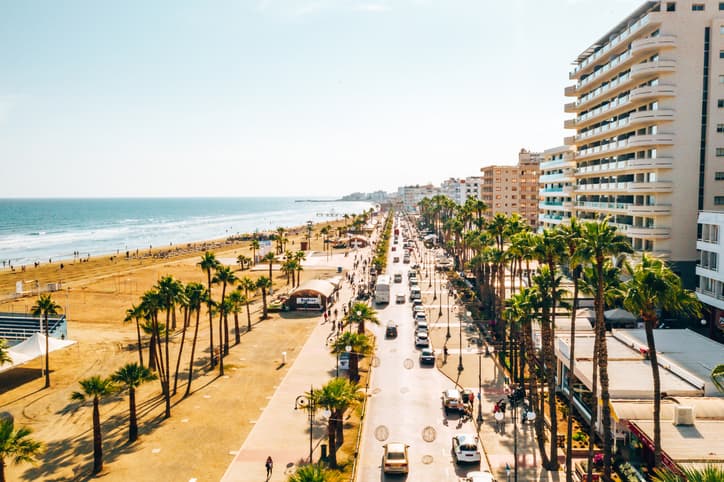 Sea front in Larnaca with palm trees and road with cars