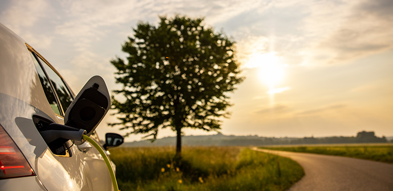 An EV is shown in a countryside location