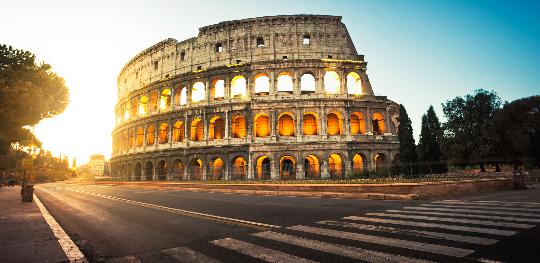 View of the coloseum in Rome lit from behind in the evening