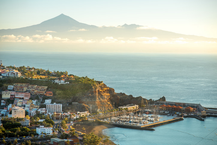 The harbour and ferry port of San Sebastian de La Gomera with the town behind blue sky and sea