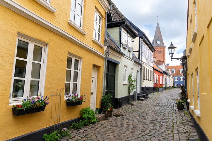 Yellow painted houses and narrow cobbled street in Aalborg